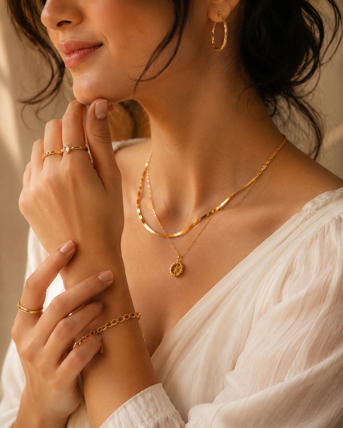 Woman wearing layered gold necklaces, rings and bracelet